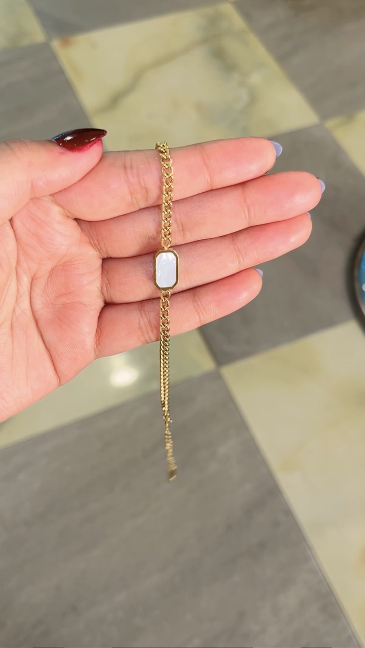Gold curb chain bracelet with mother of pearl charm