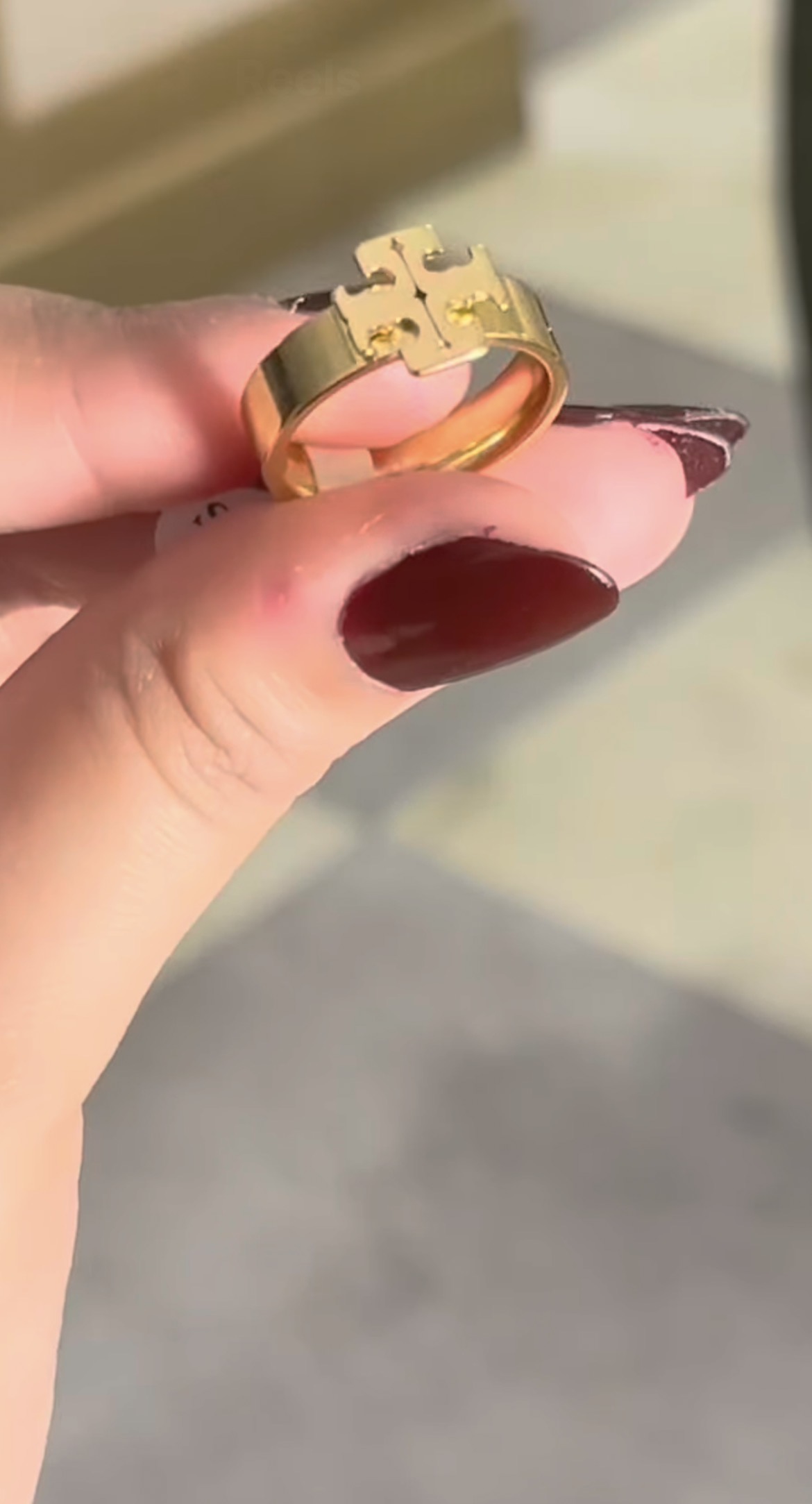 Bold gold-tone signet ring with a raised emblem face